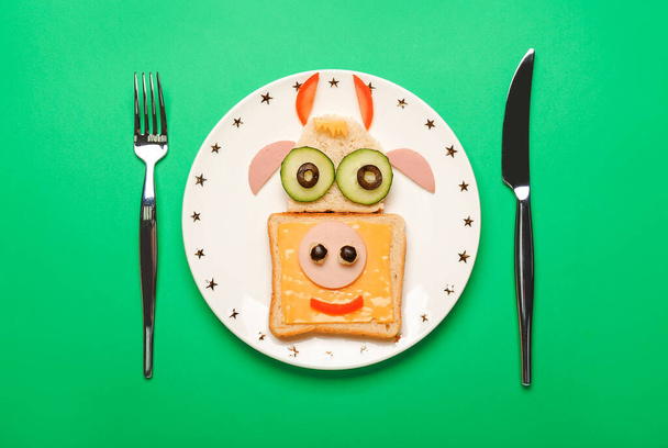 Πιάτο με νόστιμο σάντουιτς σε σχήμα ταύρου στο φόντο χρώμα - Φωτογραφία, εικόνα