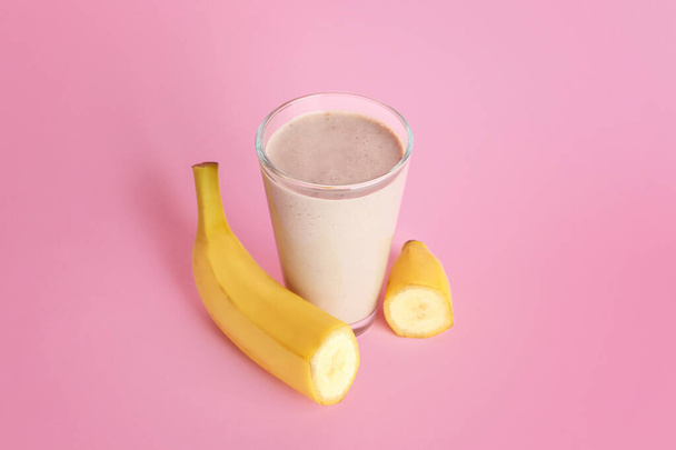 Glass of tasty banana smoothie on color background - Photo, Image