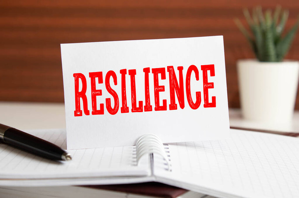 Resiliencia escrita en el bloc de notas en una mesa. concepto - Foto, Imagen