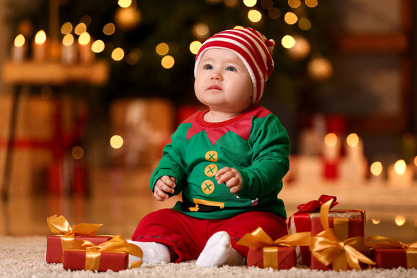 Bebê bonito no traje de elfo e com presentes em casa na véspera de Natal - Foto, Imagem