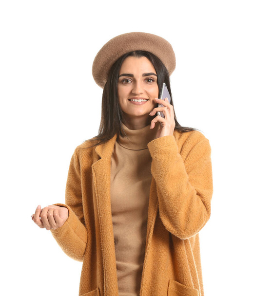 Young woman with talking by mobile phone on white background - Zdjęcie, obraz