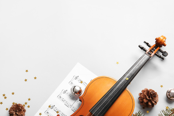 Violin with Christmas decor and music notes on light background - Foto, Imagem