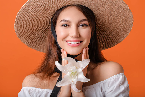 Beautiful young woman with fresh lily on color background - Fotoğraf, Görsel