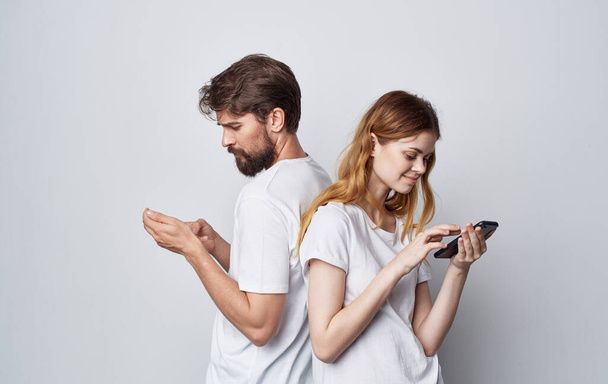 jovem casal branco t-shirt com telefone círculo social estilo de vida amizade - Foto, Imagem
