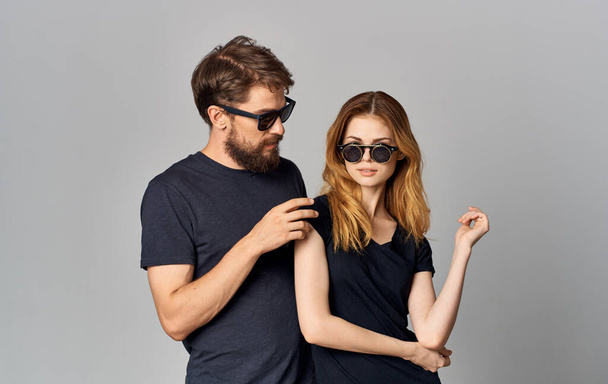 jeune couple portant des lunettes noires t-shirts noirs vêtements décontractés style de vie studio - Photo, image