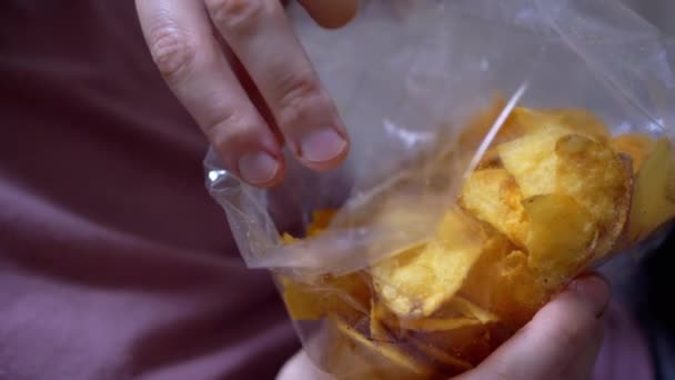 La mano femenina toma patatas fritas crujientes y doradas de Pack. Primer plano - Imágenes, Vídeo