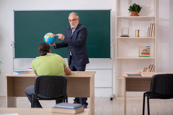 Idős földrajz tanár és férfi diák az osztályteremben - Fotó, kép