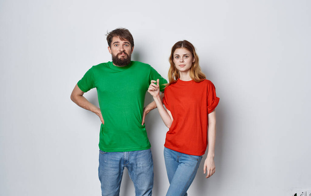 χαρούμενο νεαρό ζευγάρι σε πολύχρωμα t-shirts ζωή στούντιο συναισθήματα απομονωμένο υπόβαθρο - Φωτογραφία, εικόνα