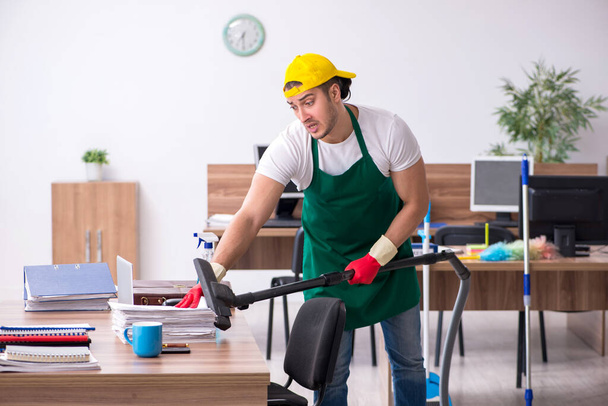 Fiatal férfi vállalkozó takarítás az irodában - Fotó, kép