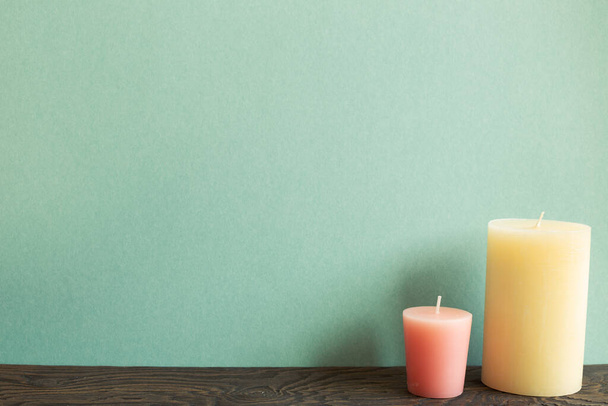 Color candles on wooden table. green background - Photo, Image