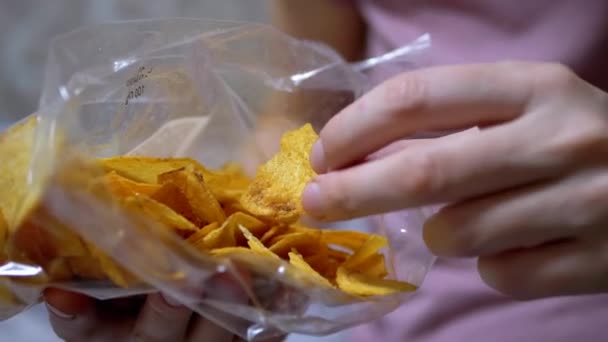 Main féminine prend croustillant, Golden Patate Chips, de Pack. Gros plan - Séquence, vidéo