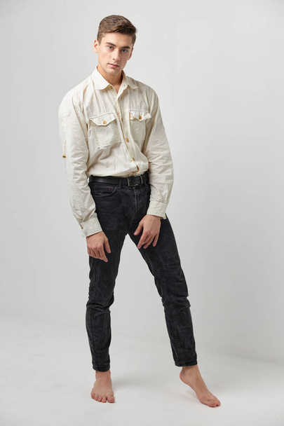 man in white shirts black pants and posing fashion lifestyle - Zdjęcie, obraz