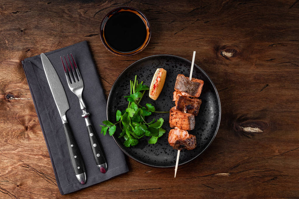  Baked salmon red fish kebab with lemon and herbs on wooden background, top view. High quality photo - Zdjęcie, obraz