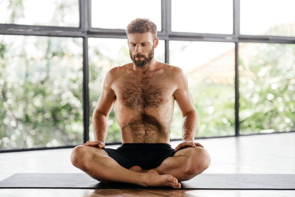 Yoga men workout in studio in front of a window - Foto, immagini