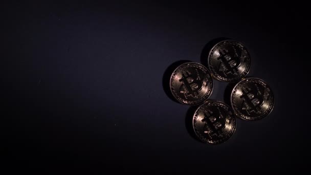 four bitcoin coins on a black background, a bright beam of light. Cryptocurrency rate concept - Footage, Video