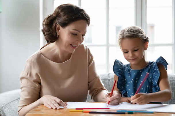 Close up smiling mature grandmother and granddaughter drawing together - Фото, зображення