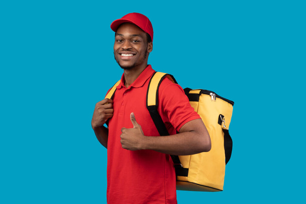 Black delivery man posing with thermo bag showing thumb up - Φωτογραφία, εικόνα
