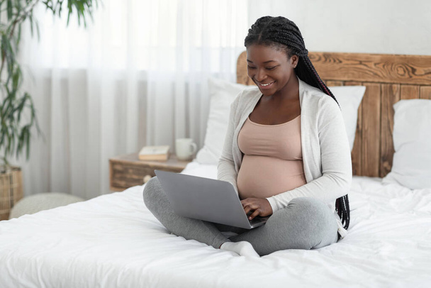 Online Shopping. Cheerful Black Expectant Mother Using Laptop Computer At Home - 写真・画像
