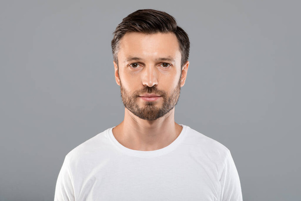 Portrait of handsome bearded man on grey background - Photo, Image