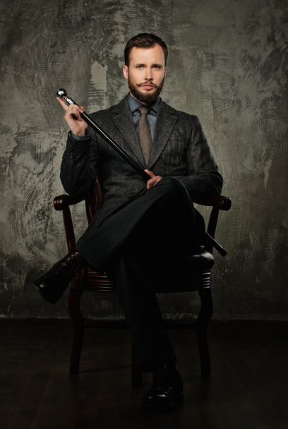 Handsome well-dressed with stick sitting in leather chair  - Fotografie, Obrázek