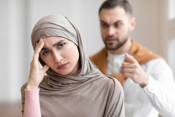 Dühös muszlim férj kiabál boldogtalan felesége áll otthon - Fotó, kép