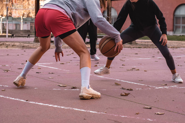 Unknown girls playing basketball on an urban court - 写真・画像
