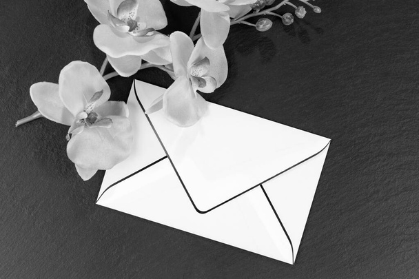Κενή κάρτα πένθους με ορχιδέες ως διακόσμηση σε ασπρόμαυρο - Φωτογραφία, εικόνα