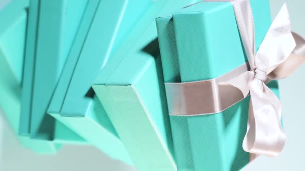 Vídeo vertical de una pila de cajas azul turquesa atadas con cinta de seda blanca - Metraje, vídeo