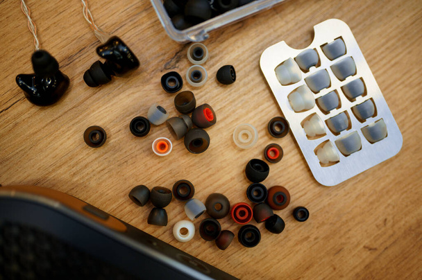Earpieces rubbers on the counter in audio store, nobody. Lots of ear pads. Speaker system choice, stand with earphones, multimedia salon assortment, music devices shop - Photo, Image