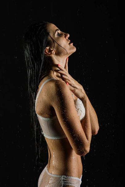Jeune femme avec beau corps sportif en parfaite forme avec gouttes d'eau en lingerie blanche en aquastudio - Photo, image