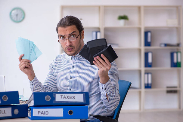Jeune comptable calculant les paiements d'impôts au bureau - Photo, image
