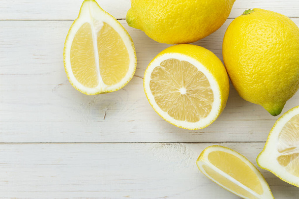 Ripe lemons on a white wooden table. - Φωτογραφία, εικόνα
