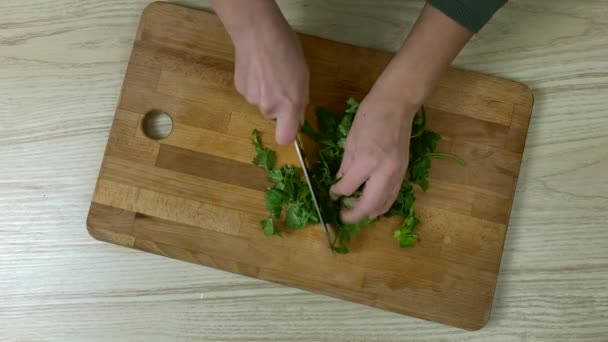 Woman cutting parsley on wooden boar - Footage, Video