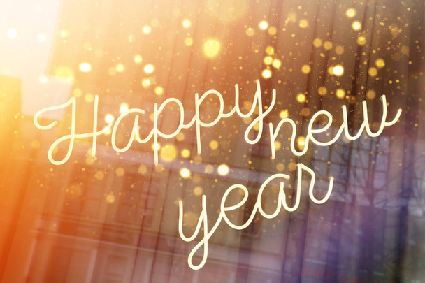 Χειρόγραφες λέξεις: Ευτυχισμένο το Νέο Έτος εορταστική επιγραφή στο γυαλί στο δρόμο, αντανάκλαση στο γυαλί των κτιρίων. - Φωτογραφία, εικόνα