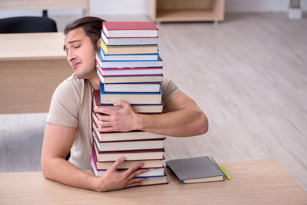 Joven estudiante masculino preparándose para los exámenes en la biblioteca - Foto, imagen