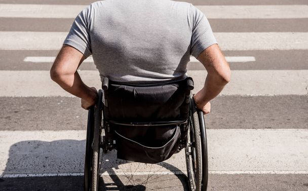 Handicapped man in wheelchair crossing street road - Fotó, kép