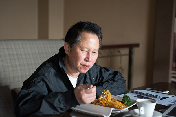 Keski-ikäinen mies syö nuudeleita
  - Valokuva, kuva
