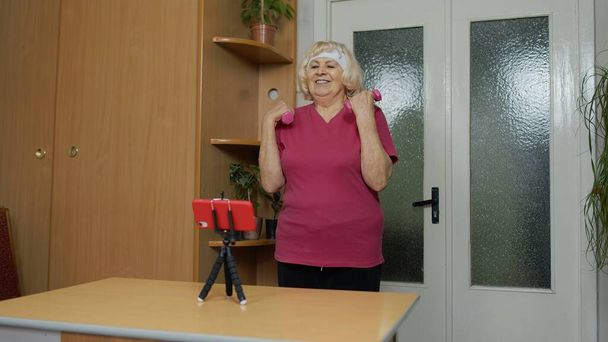Mujer mayor jubilada haciendo ejercicios, entrenamiento, fitness, ejercicios de actividad deportiva durante el coronavirus - Foto, imagen