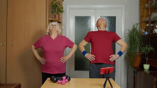 Idős férfi nő csinál fitness gyakorlatok kezdő élő stream, vlog, blog, online távolság tanfolyam - Fotó, kép