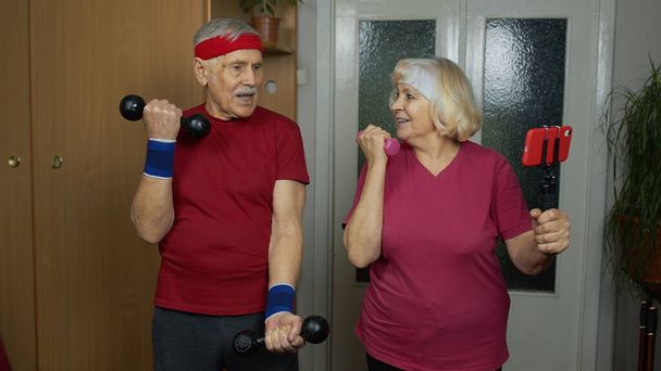 Пожилая пара бабушка дедушка делает тренировку с гантелями, фитнес-упражнения - Фото, изображение