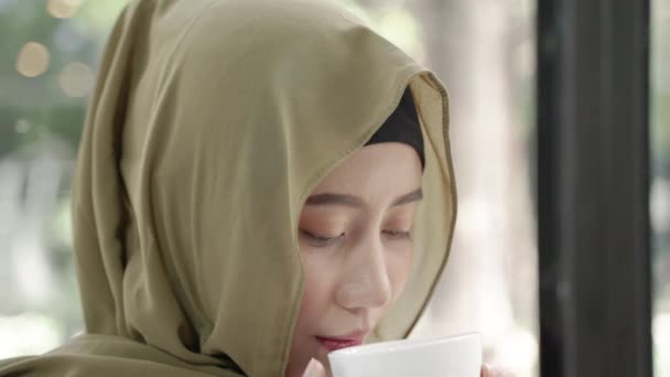 Vídeo de cerca de una mujer musulmana bebiendo café o té caliente - Imágenes, Vídeo