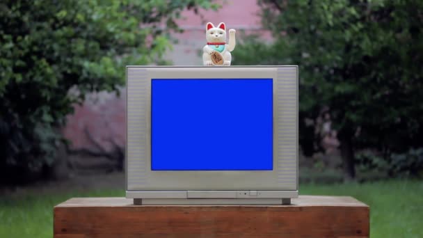 青い画面の古いテレビで招き猫ラッキー猫.ズームイン。青い画面を必要な映像や画像に置き換えることができます。After Effectsやその他のビデオ編集ソフトウェアのキーエフェクトで実行できます。.  - 映像、動画