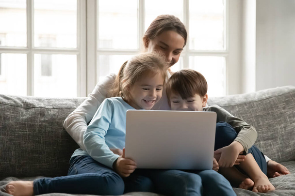 Крупним планом мати і двоє дітей розважаються з ноутбуком
 - Фото, зображення