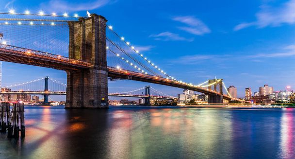 夕暮れ時のブルックリン橋。米国ニューヨーク市。ブルックリン橋はロウアー・マンハッタンとブルックリンを結んでいる。. - 写真・画像