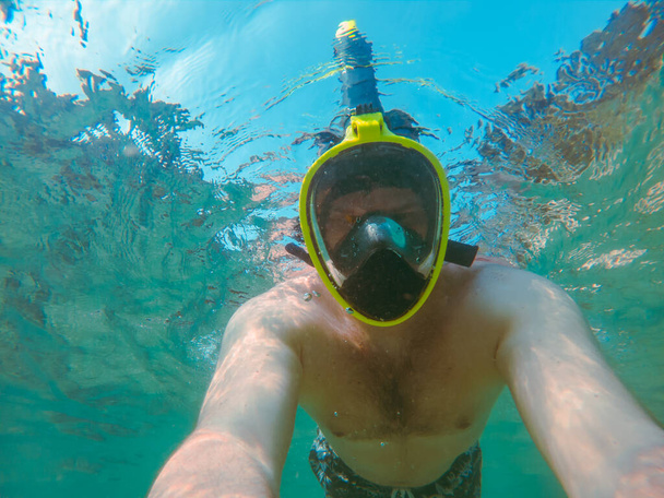 человек с маской для подводного плавания под водой летний отдых на море прозрачная вода - Фото, изображение