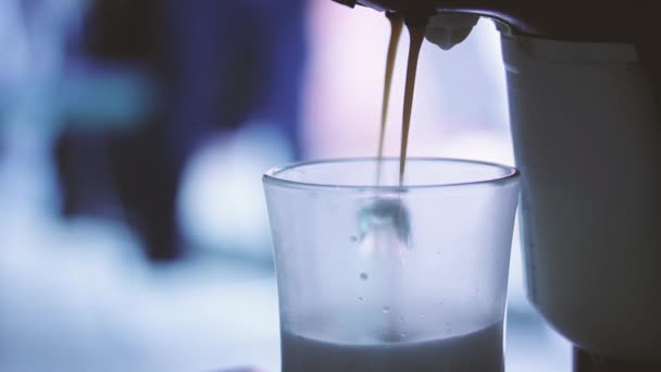 エスプレッソマシンはホットミルクとコーヒーをコーヒーカップに注ぎます。クローズアップ.   - 映像、動画