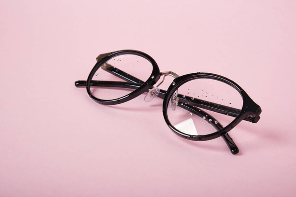 glasses in black frame on a pink background copy space - Foto, Imagem