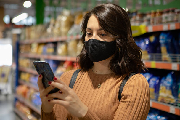 ritratto della donna al negozio di alimentari con maschera con spazio di copia del telefono - Foto, immagini