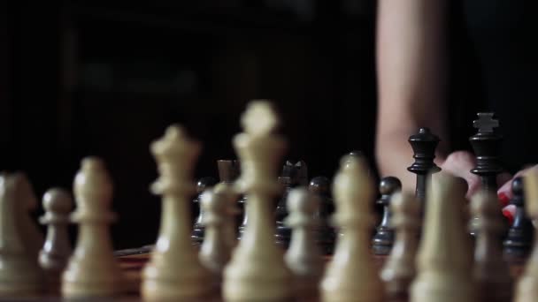 黒とチェスをしている塗装爪を持つ若い女性。クローズアップ.   - 映像、動画