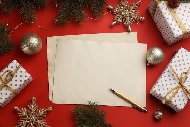 Flat lay composition with blank sheets of paper on red background, space for text. Writing letter to Santa - 写真・画像